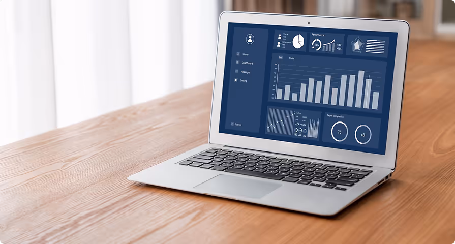 Laptop on wooden table displaying a dashboard with various charts and performance graphs.